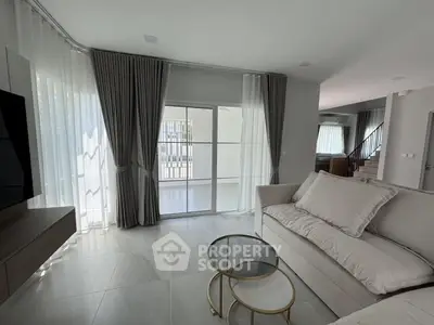 Elegant living room with modern decor, large windows, and stylish furniture in a contemporary home.
