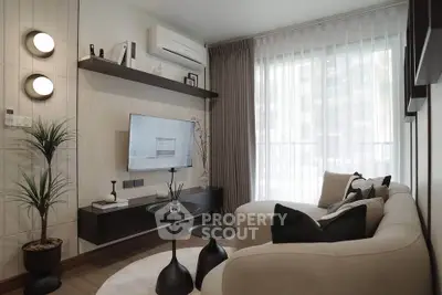 Modern living room with stylish decor, large window, and cozy seating area.