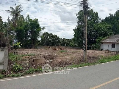 Vacant land plot with road access and lush greenery, ideal for development opportunities.