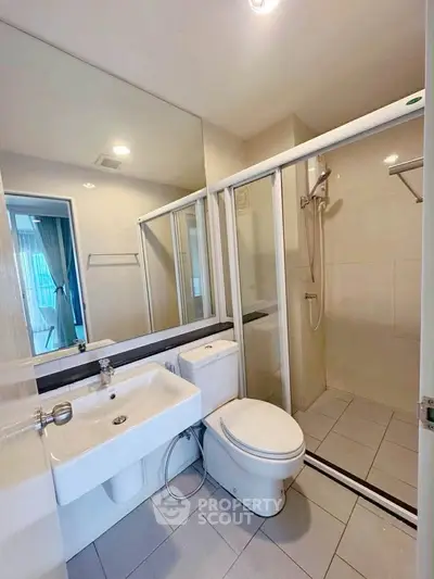 Modern bathroom with glass shower and sleek fixtures in a contemporary apartment.