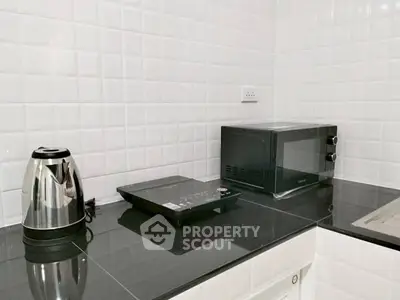 Modern kitchen with sleek black countertop and appliances