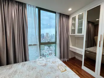 Modern bedroom with city view, featuring elegant curtains and built-in wardrobe.
