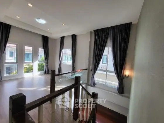 Spacious and bright interior with large windows and elegant curtains