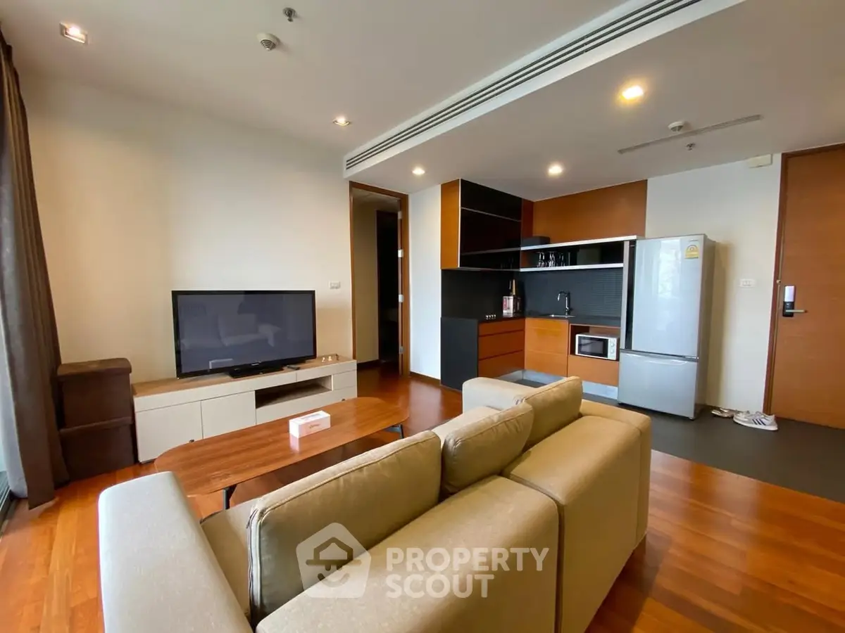 Modern living room with open kitchen and sleek appliances in a stylish apartment.