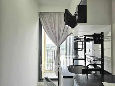 Modern kitchen with sleek black countertops and balcony view