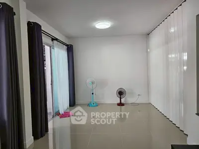 Spacious empty room with glossy tiled floors and sliding glass doors.