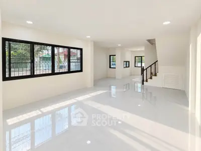 Spacious modern living room with large windows and glossy floors