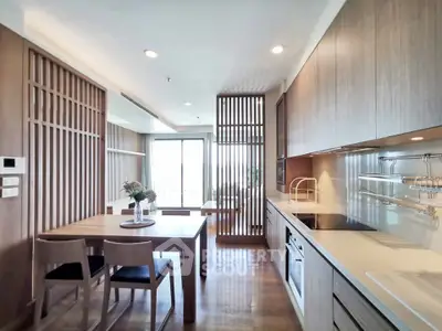 Modern kitchen with sleek cabinetry and dining area in open layout apartment.