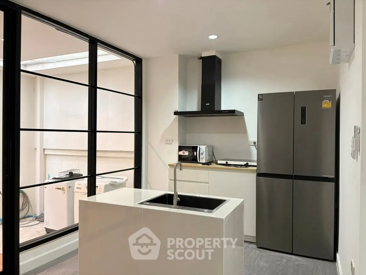 Modern kitchen with sleek appliances and island sink in stylish home