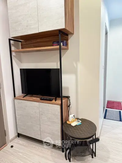 Modern living room with sleek TV stand and stylish side table in cozy apartment.