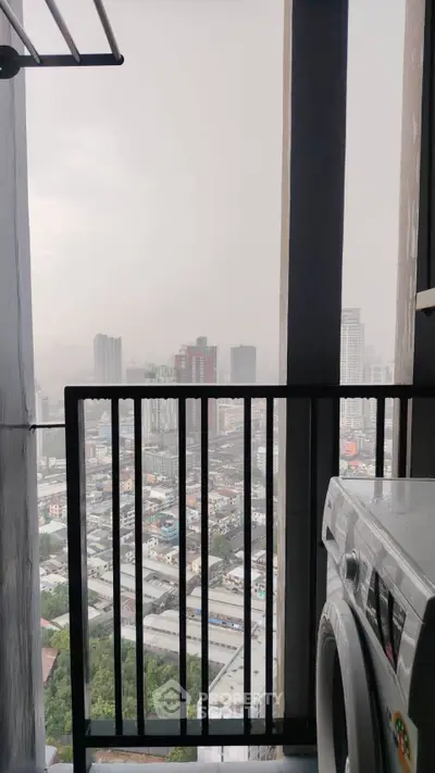 High-rise balcony with cityscape view and washing machine