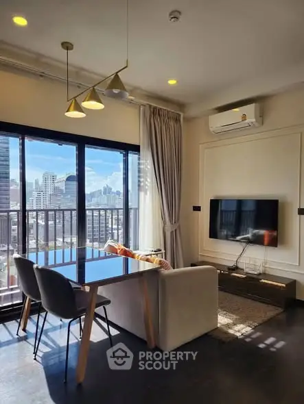 Modern living room with city view, featuring sleek furniture and large windows.