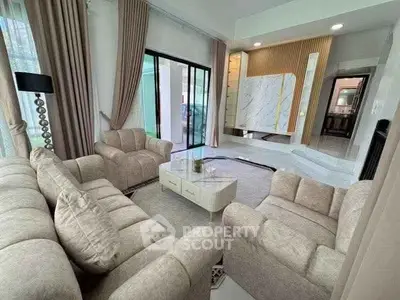 Luxurious living room with plush sofas and modern decor, featuring large windows and elegant curtains.