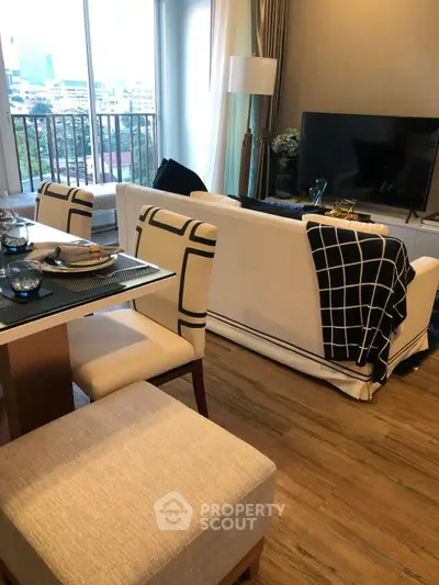Stylish living room with modern decor and city view balcony, perfect for urban living.