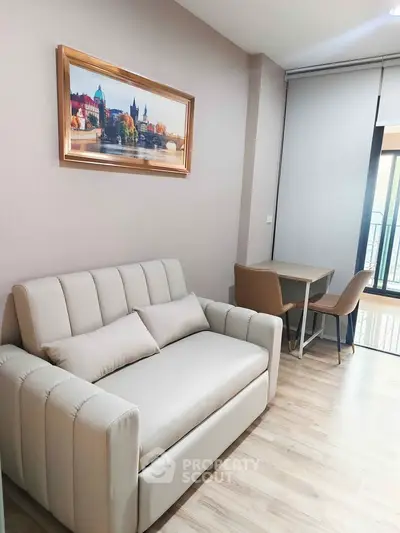 Modern living room with cozy sofa and dining area, featuring elegant decor and natural light.