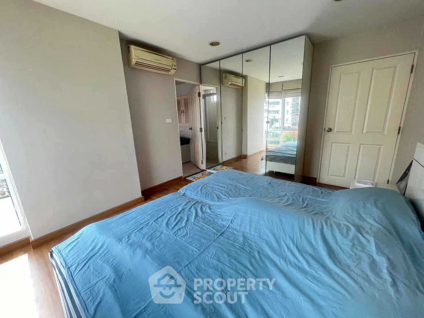 Spacious bedroom with mirrored closets and air conditioning in modern apartment
