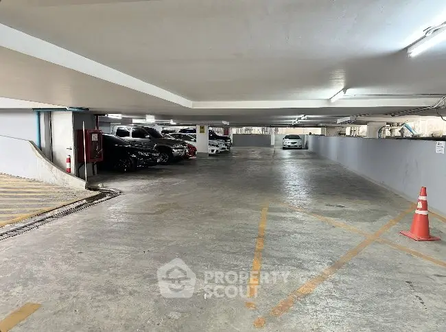 Spacious underground parking area with ample lighting and marked spaces.