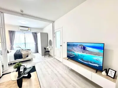 Modern living room with sleek TV and open view to stylish bedroom