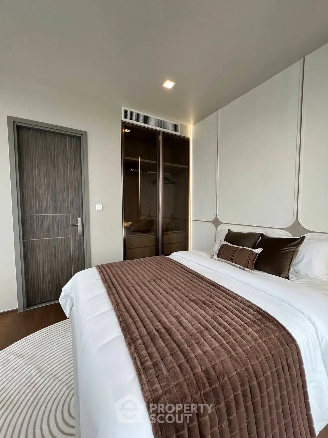 Luxurious bedroom with elegant decor and plush bedding in modern apartment.