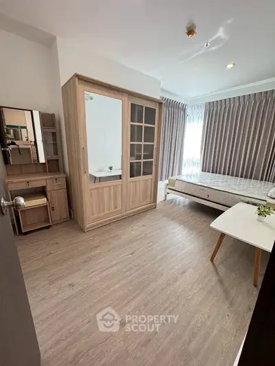 Spacious bedroom with modern wooden furniture and natural light