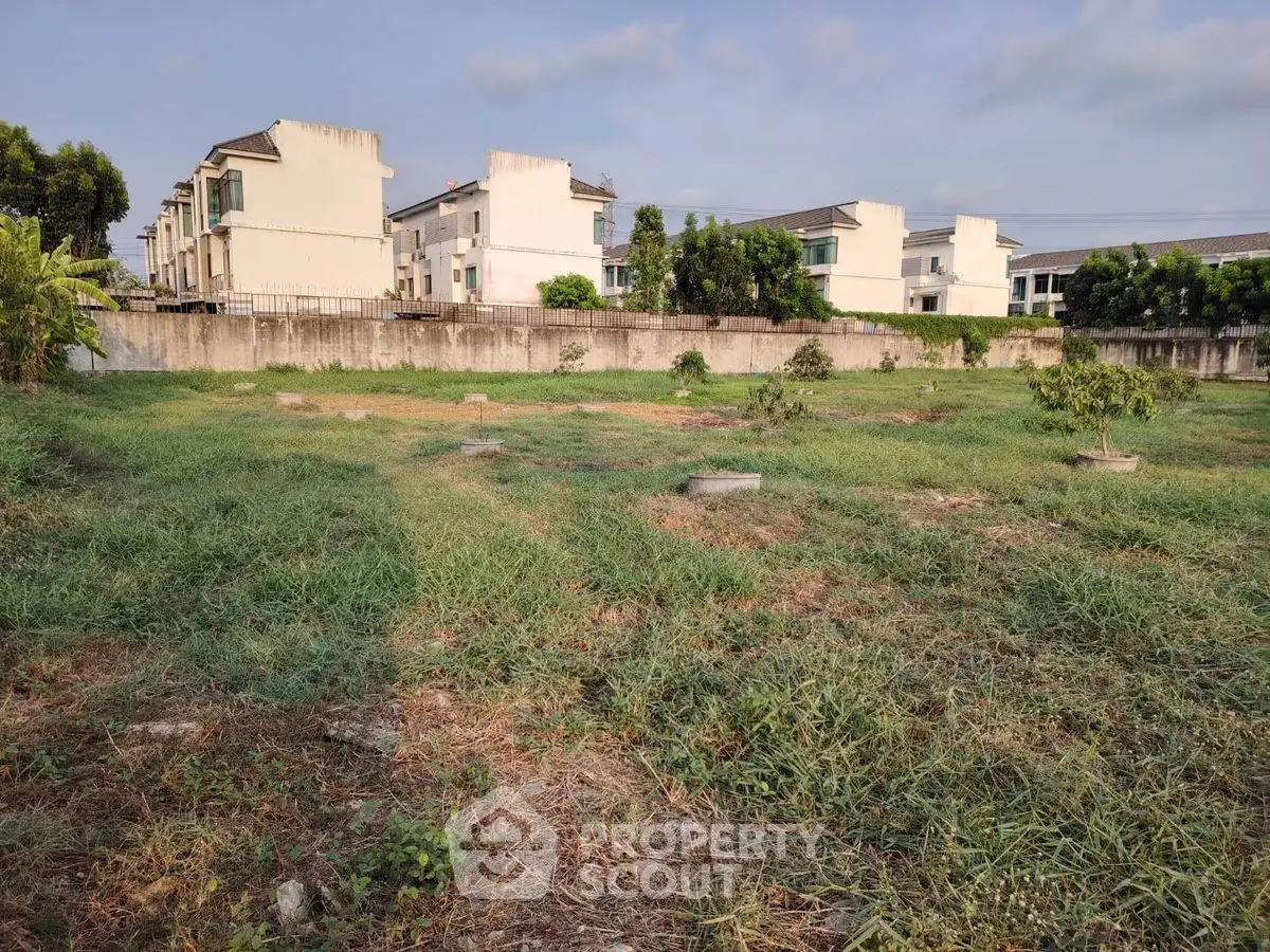 Spacious vacant land with lush greenery, ideal for development in a serene neighborhood.