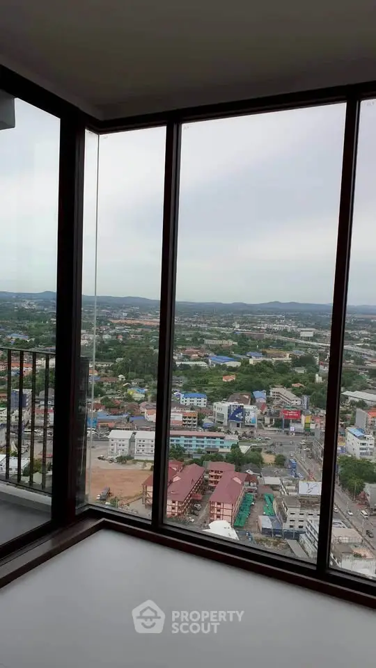 Stunning high-rise view from a modern apartment with floor-to-ceiling windows overlooking the cityscape.