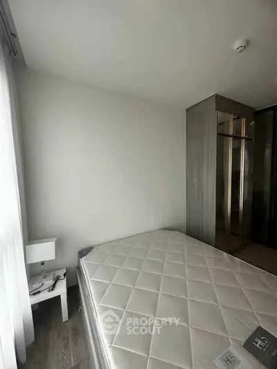 Modern bedroom with sleek design and ample natural light, featuring a large wardrobe and minimalist decor.