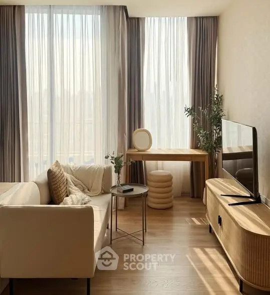 Elegant living room with modern furniture and large windows offering natural light.