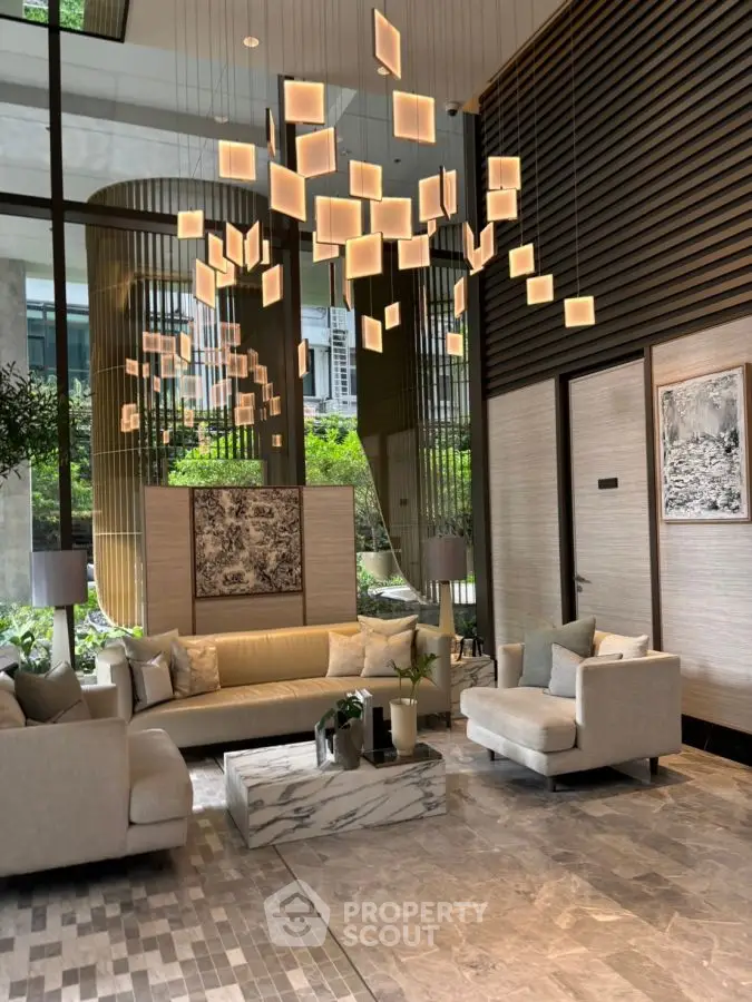 Luxurious modern living room with elegant chandelier and marble accents in a high-end property.