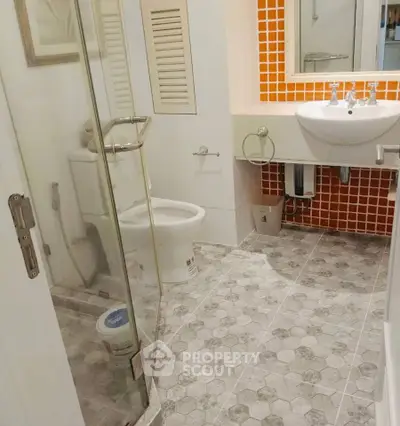 Modern bathroom with glass shower and orange tile accents