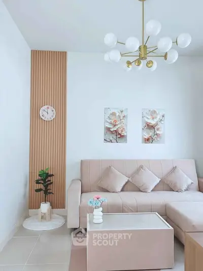 Elegant living room with modern chandelier, plush sofa, and stylish decor in a cozy setting.