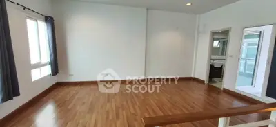 Spacious empty room with wooden flooring and large windows, ideal for customization.