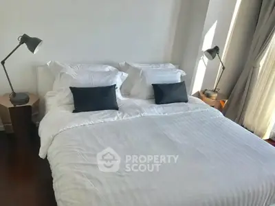 Modern bedroom with stylish lamps and natural light, perfect for relaxation and comfort.