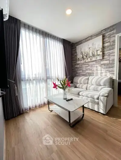 Modern living room with stylish decor and large window for natural light.