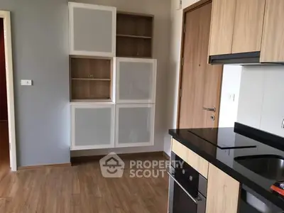 Modern kitchen with sleek cabinets and built-in oven in a stylish apartment.