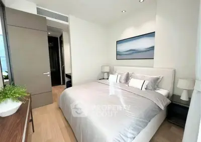 Modern bedroom with stylish decor and natural light, featuring a comfortable bed and elegant furnishings.