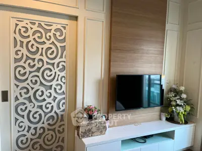 Stylish living room with modern TV setup and decorative wall paneling.