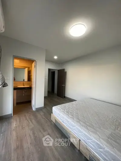 Spacious bedroom with ensuite bathroom and modern flooring