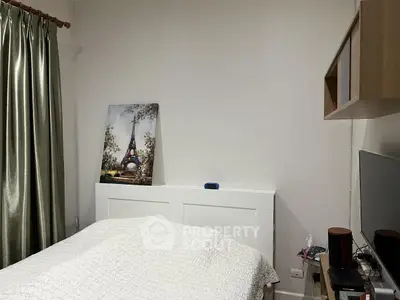 Cozy bedroom with elegant decor and wall art, featuring a comfortable bed and modern furnishings.