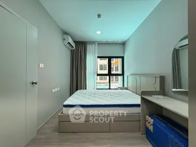 Modern bedroom with minimalist design, featuring a comfortable bed, air conditioning, and ample natural light.