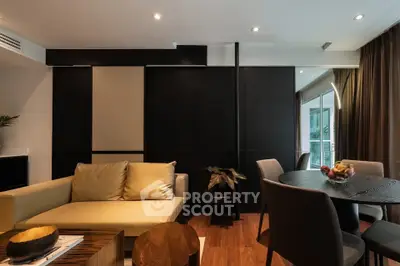 Modern living room with elegant decor and dining area, featuring sleek furniture and warm lighting.