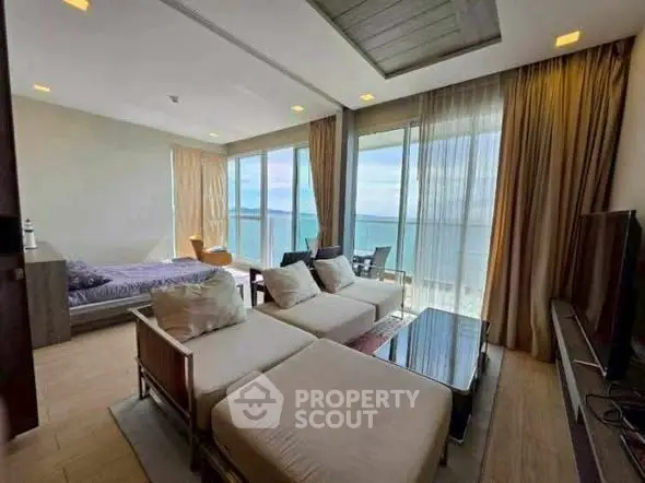 Luxurious beachfront living room with panoramic ocean views and modern furnishings.