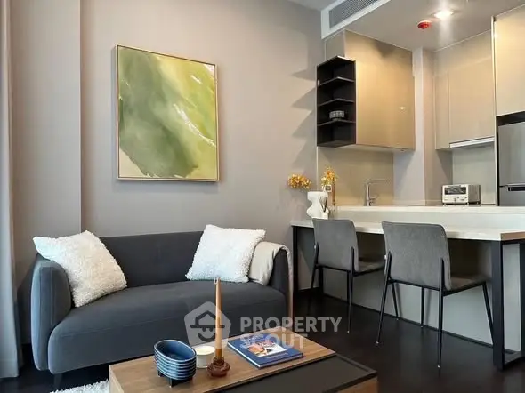 Modern living room with cozy sofa and stylish kitchen area in open layout apartment.