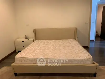 Spacious bedroom with elegant bed and modern nightstand in a serene setting.