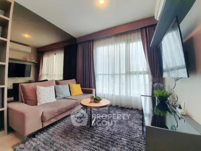 Modern living room with plush sofa, large window, and stylish decor in a cozy apartment.