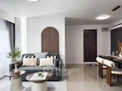 Modern living room with stylish decor and dining area in open layout apartment.