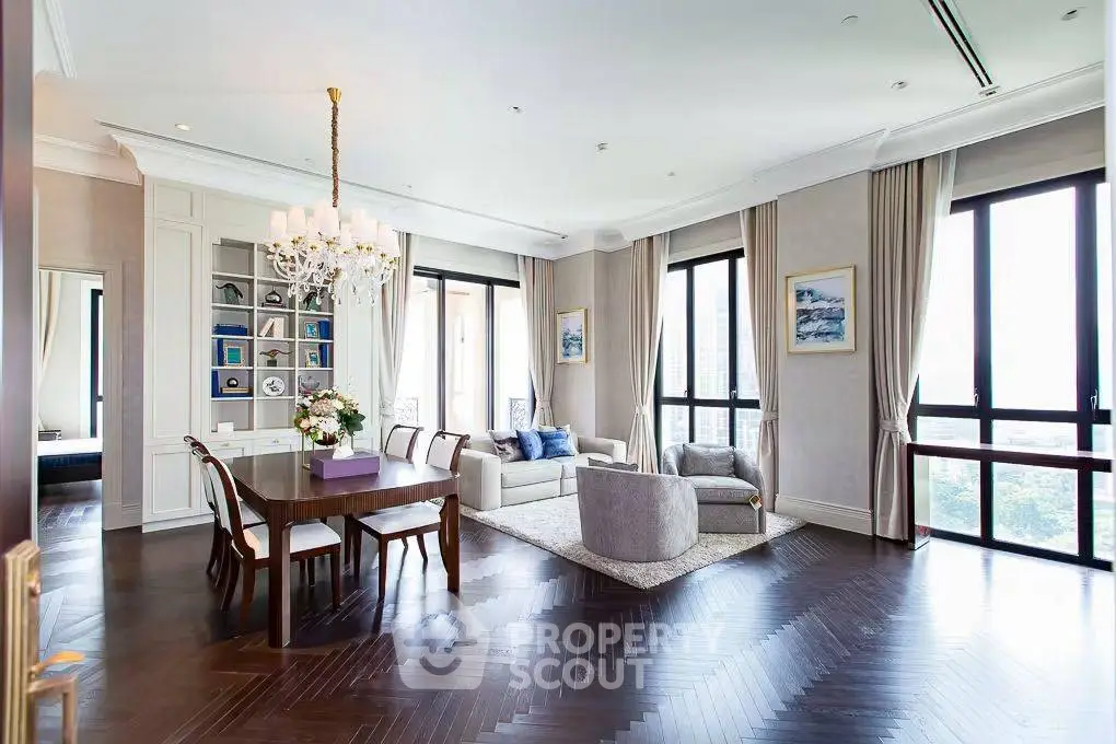 Luxurious living room with elegant decor, large windows, and a stylish chandelier in a modern apartment.