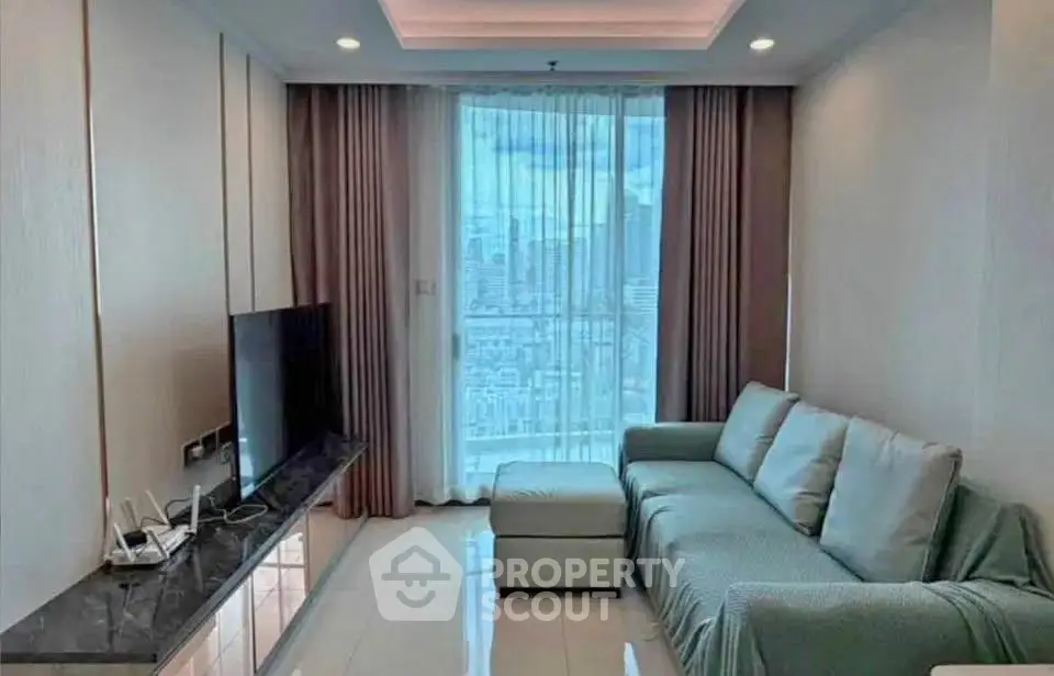 Modern living room with city view, featuring sleek TV setup and comfortable sofa.