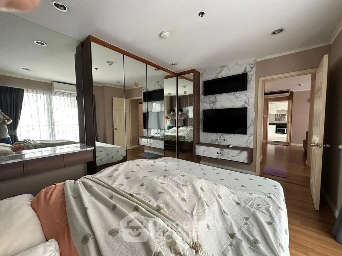 Spacious bedroom with mirrored wardrobes and modern decor