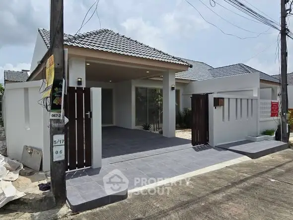 Modern single-story house with tiled roof and spacious driveway in a serene neighborhood.